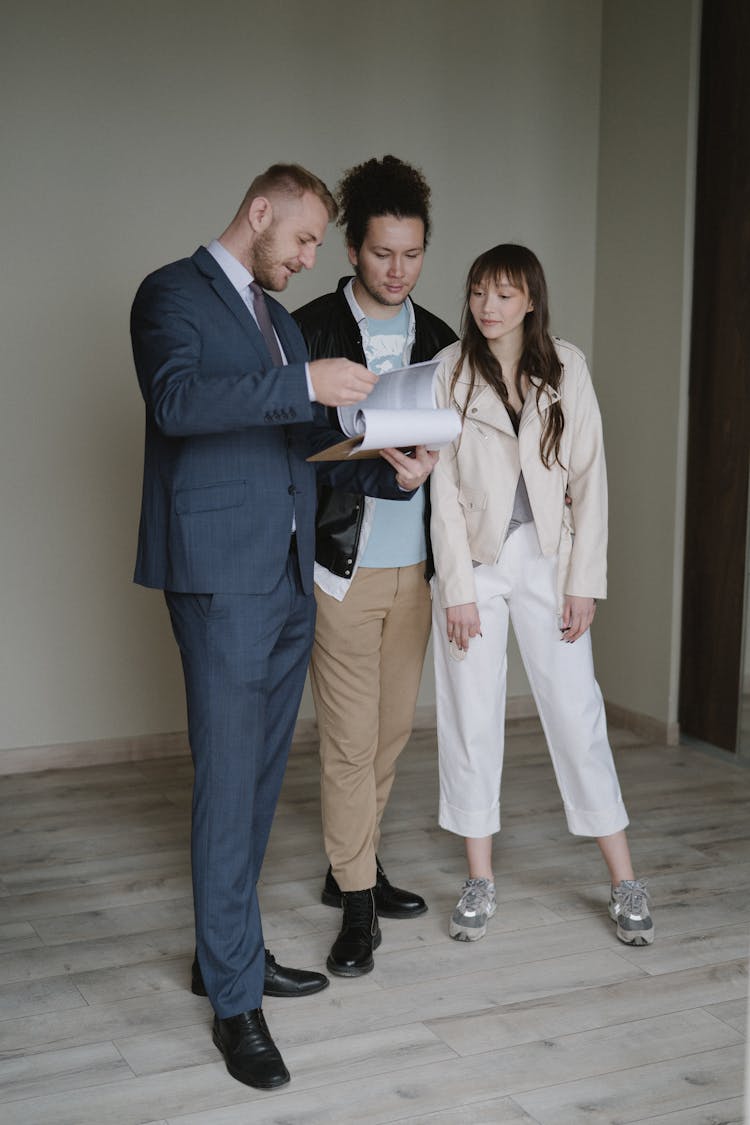 A Couple Checking The Documents Of Their New Home