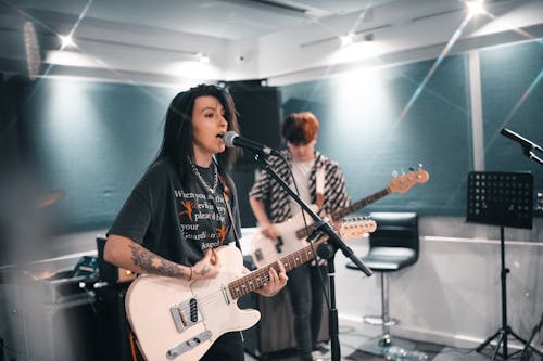 Woman Singing While Playing the Guitar