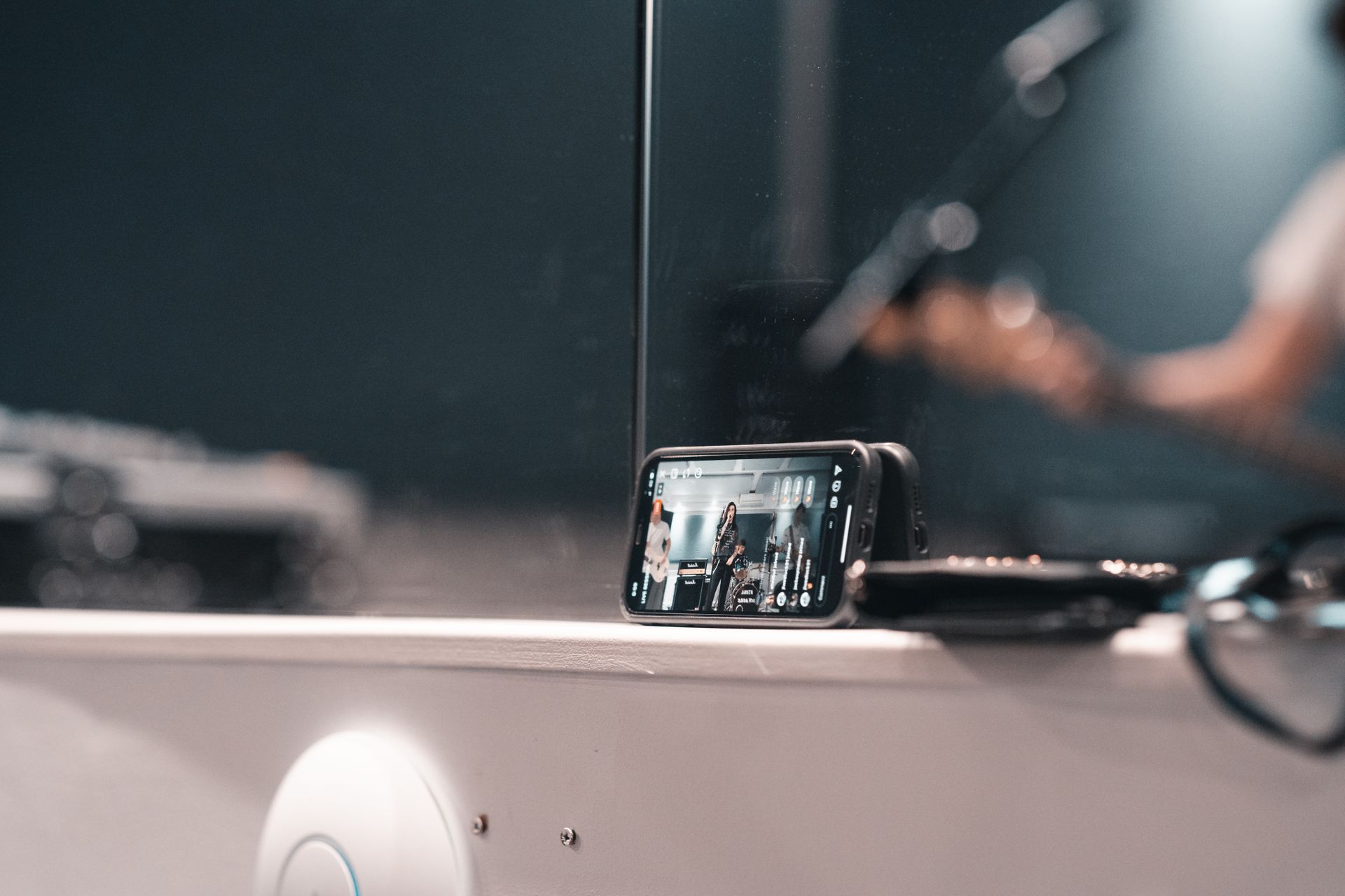 A smartphone recording a live band performance at an indoor event.