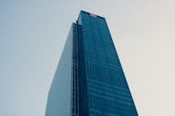 在清澈的蓝天下，一座引人注目的现代摩天大楼装有反光玻璃