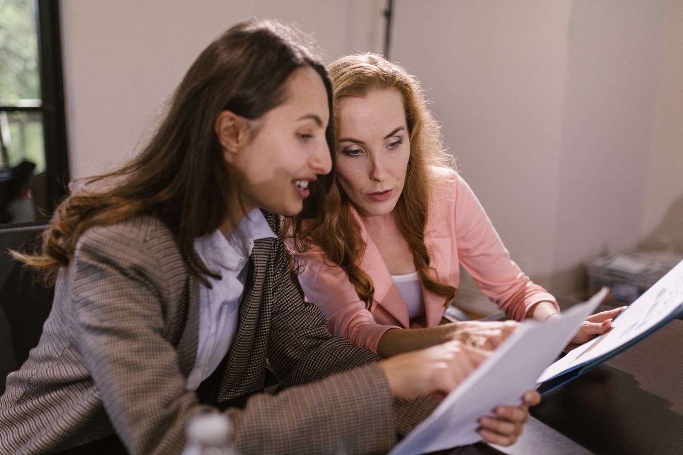 Two women working through business documents together