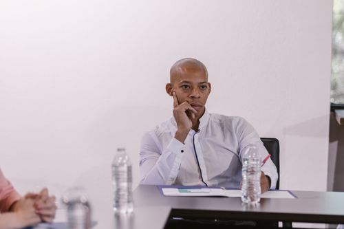 Free Thoughtful professional man engaged in a business meeting discussion, seated at a conference table. Stock Photo
