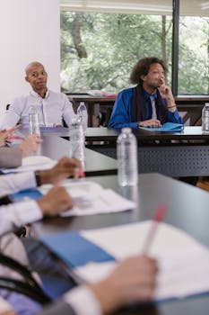 A diverse group of professionals attentively participating in a formal business meeting.