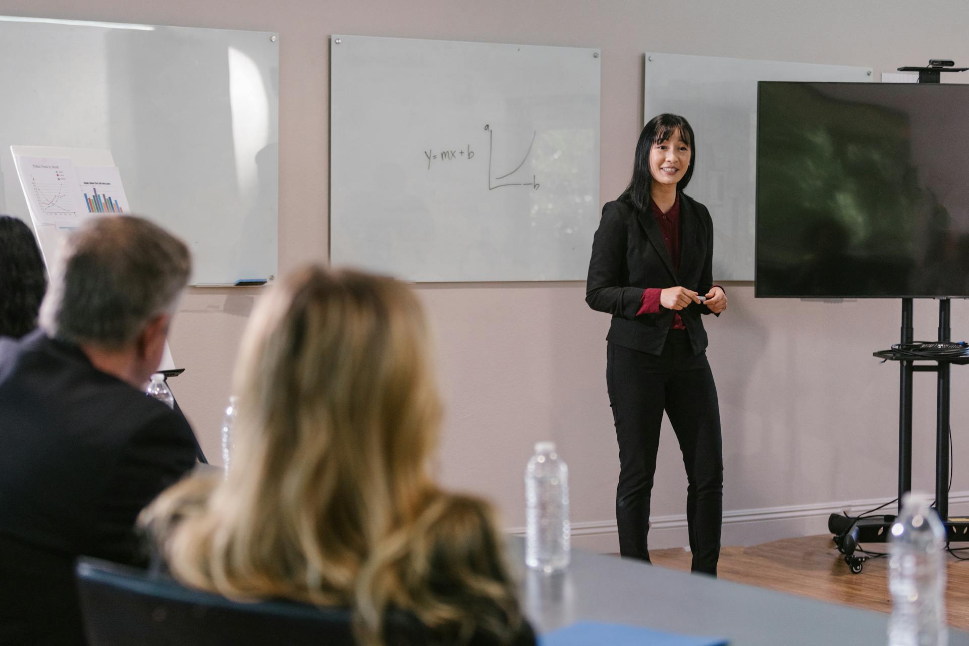 A businesswoman giving a presentation in a conference room, engaging with professionals.