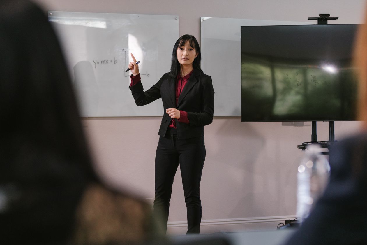 A businesswoman presenting at a business meeting, engaging with the audience in a corporate setting