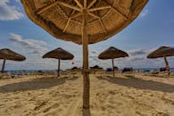 这片宁静的热带海滩配有草帽伞和躺椅，非常适合轻松度假