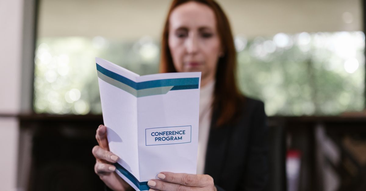 Close-up of hands holding a program booklet with
