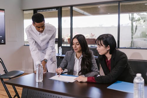 Man in White Dress Shirt Sitting Beside Woman in Black Blazer