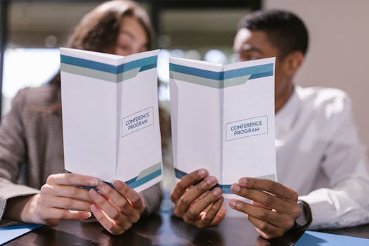 Diverse professionals discussing conference program in meeting setting.