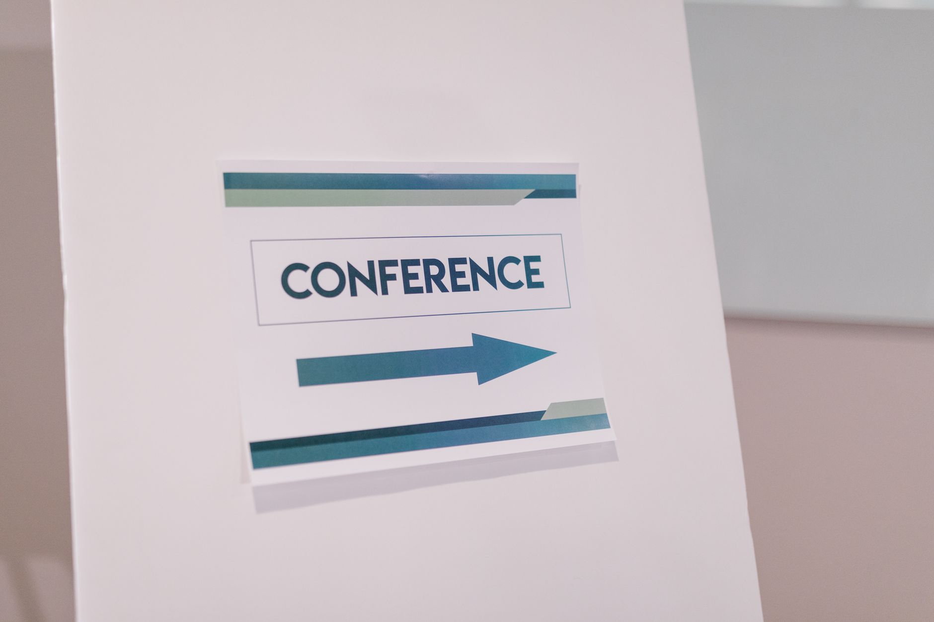 Close-up of a conference directional sign indoors, guiding participants. Related image for 2026 Europe Guest Experience Innovation Roundtable.