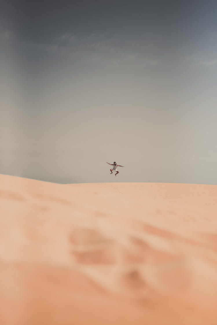 A Person Jumping On The Desert