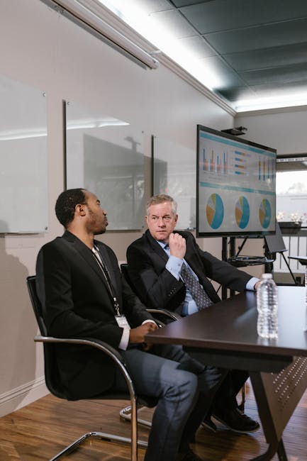Photo by RDNE Stock project Two men in business attire engage in a professional discussion in a modern office.