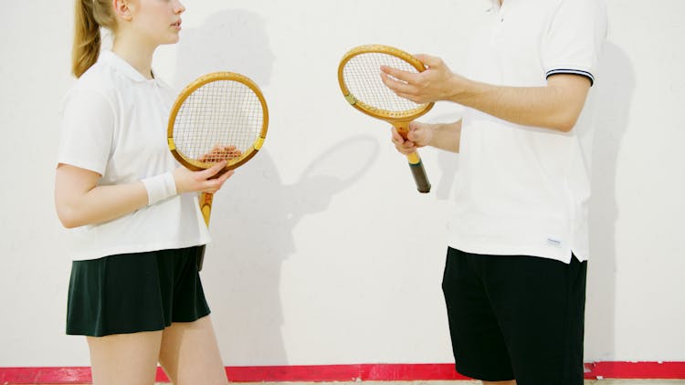 Two People Holding Rackets