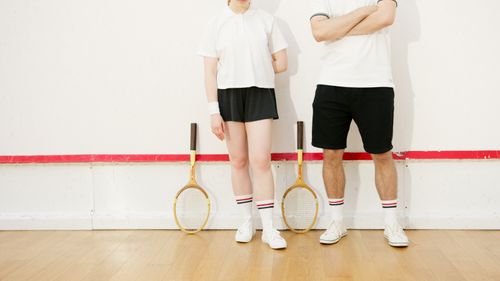 Free Two squash players in sports attire standing with wooden rackets on an indoor court. Stock Photo