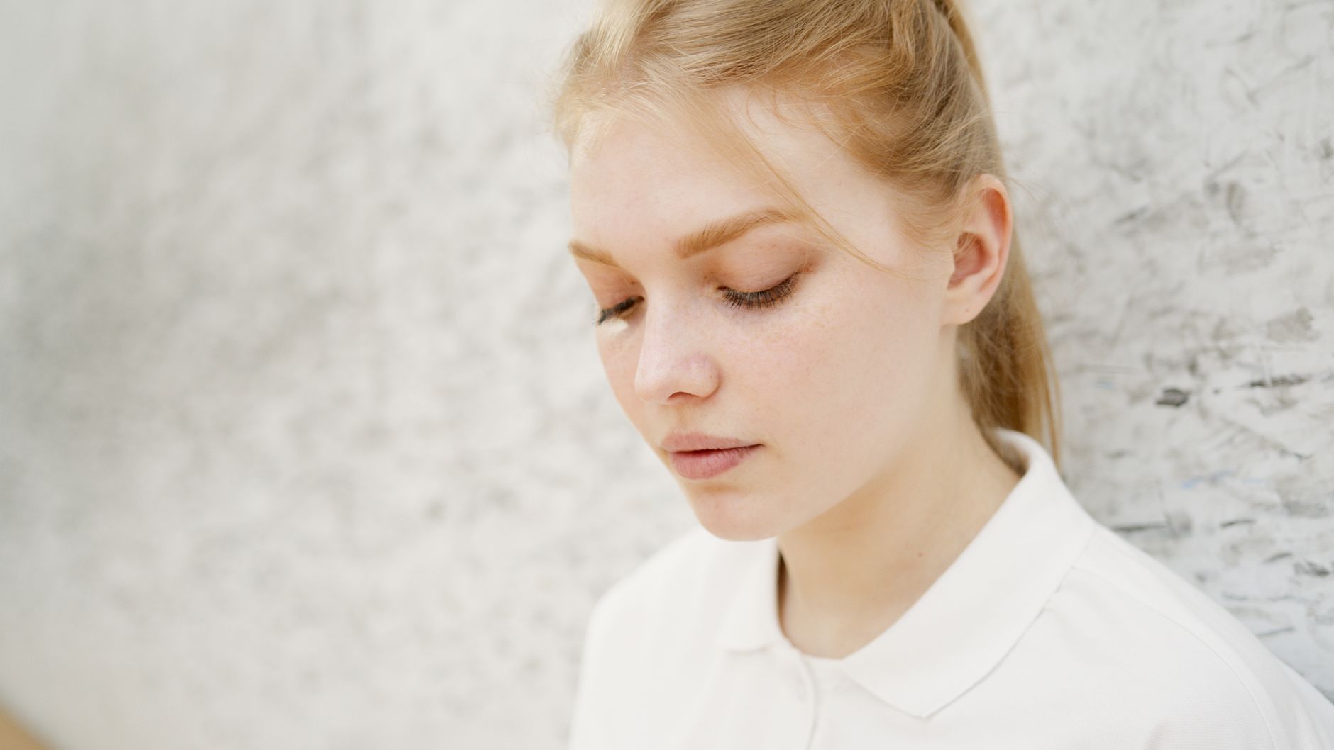Close-up portrait of a young woman with a blurred background, conveying introspection.