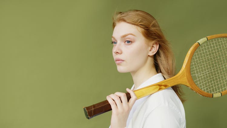 A Woman In White Shirt Holding A Tennis Racket