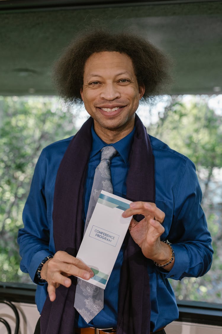 A Man Holding A Pamphlet