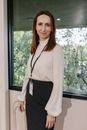 Woman in White Long Sleeve Shirt and Black Skirt Standing Near Window