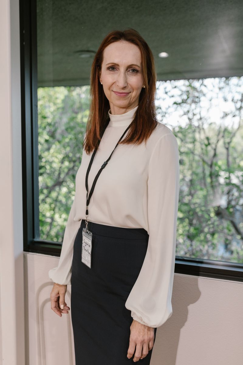 Woman in a white shirt and black skirt working in an office