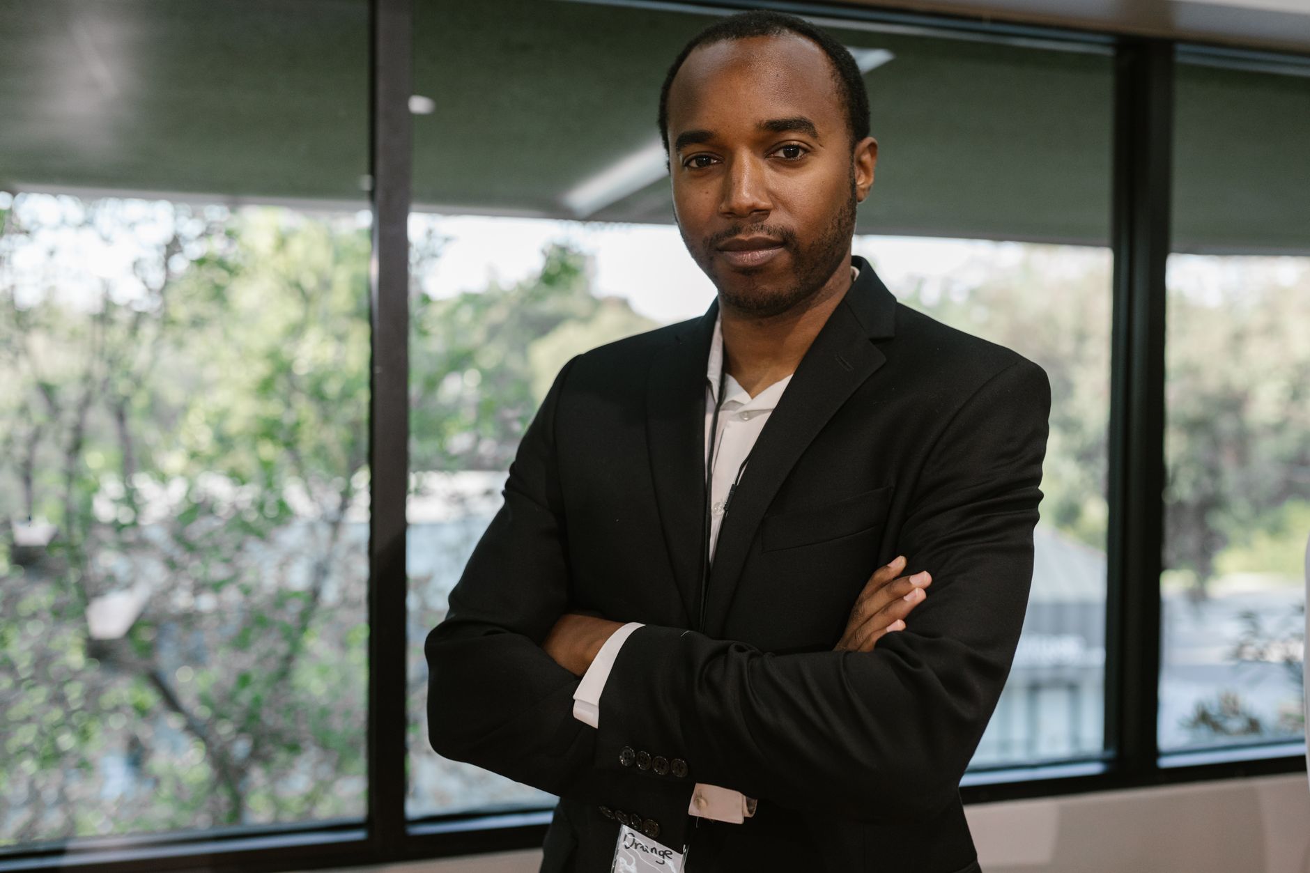 Portrait of a confident man in corporate attire inside a modern office.