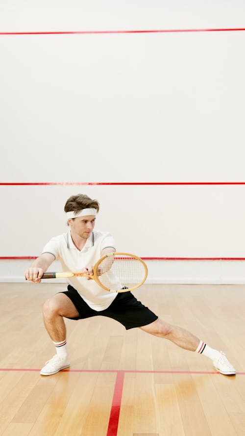 A Person Stretching While Holding a Squash Racket