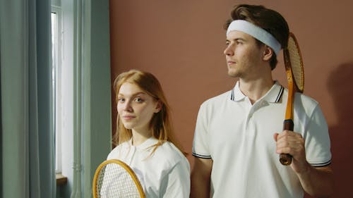 Free Man with Tennis Racket Standing Near Young Woman Stock Photo