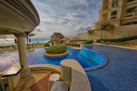 在墨西哥一家豪华度假村的泳池边，你可以放松身心，欣赏美丽的海景和棕榈树