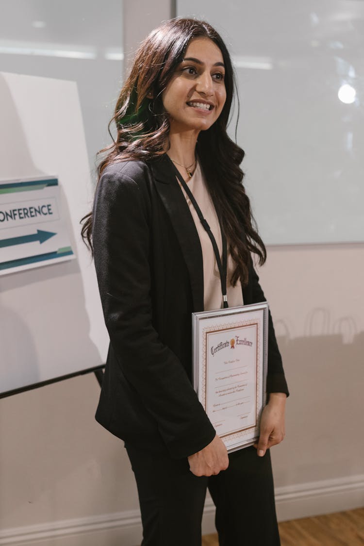 A Woman Holding A Framed Certificate