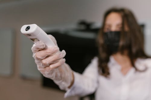 A Woman Holding an Infrared Thermometer