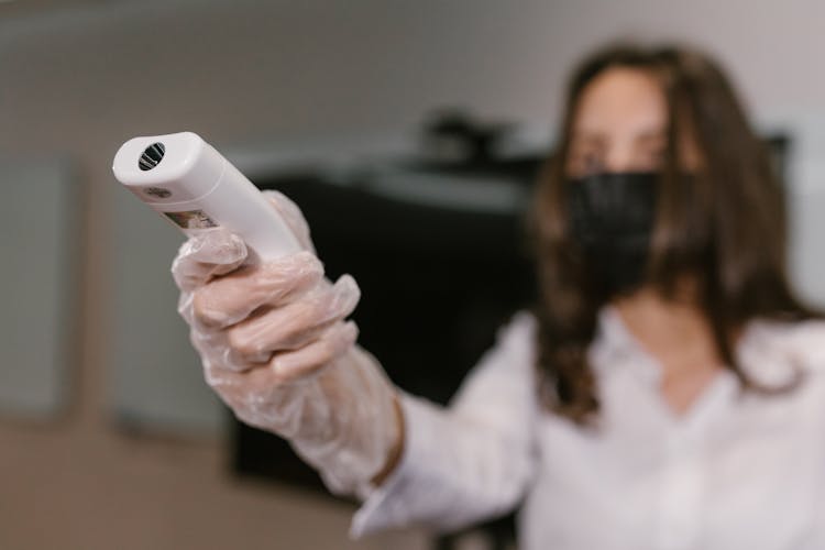 A Woman Holding An Infrared Thermometer