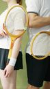 A Couple Holding a Wooden Racket