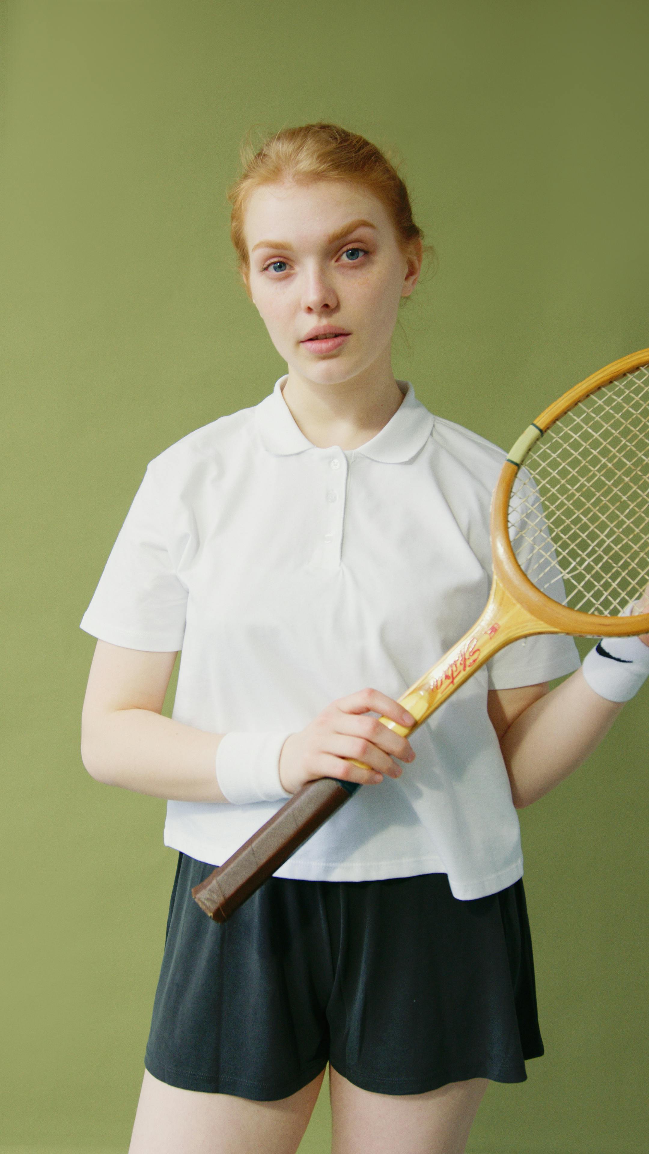 a woman with wooden racket wearing white shirt