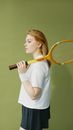 A Woman Holding a Wooden Racket on Her Shoulder
