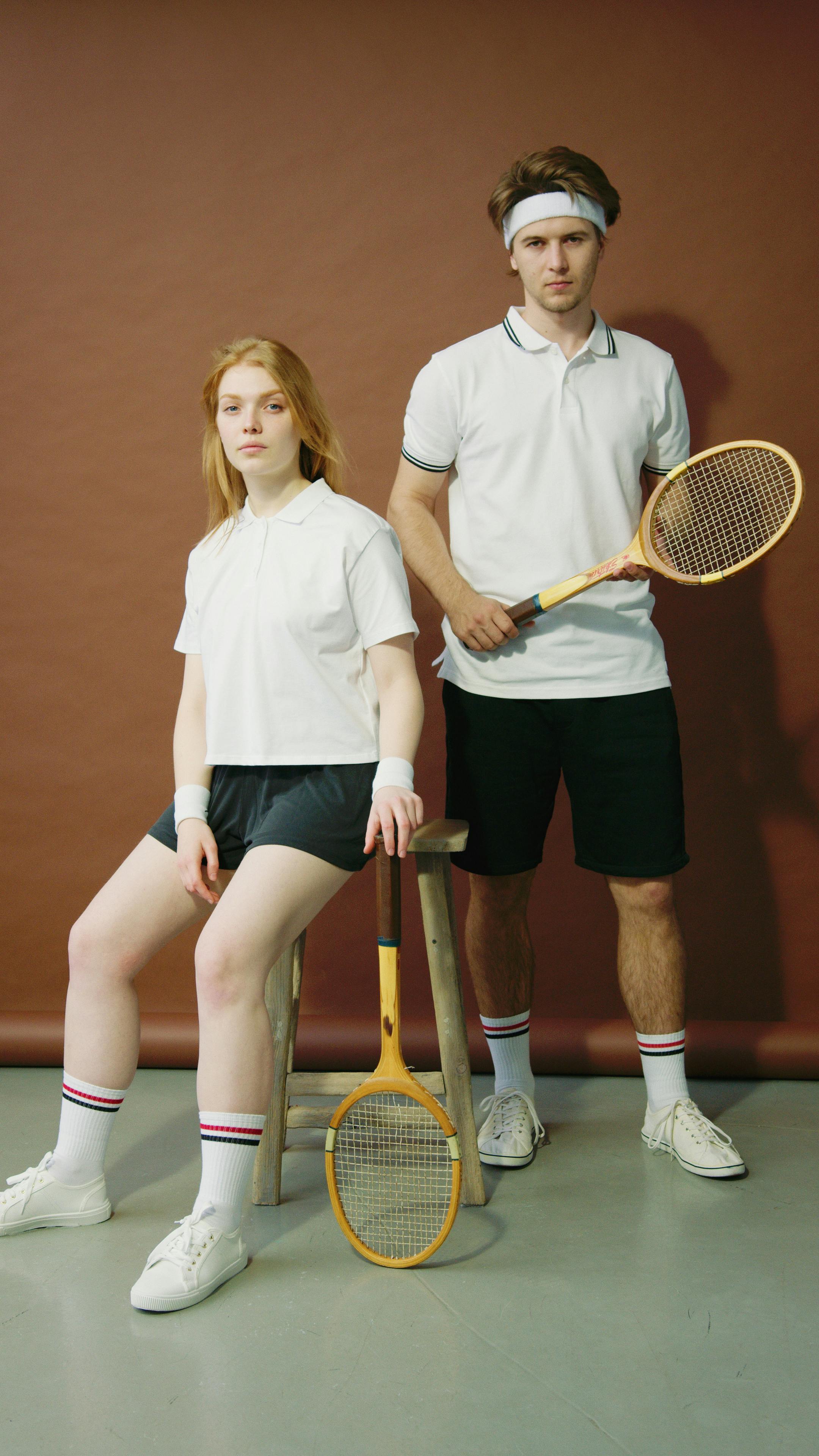 man and a woman posing with rackets