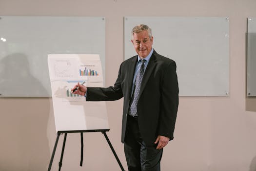 Confident senior businessman in a suit presenting graphs on a whiteboard in an office setting.