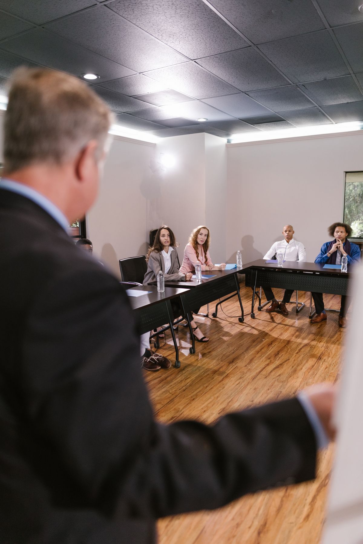 Diverse professionals listening and discussing strategy in a modern conference room