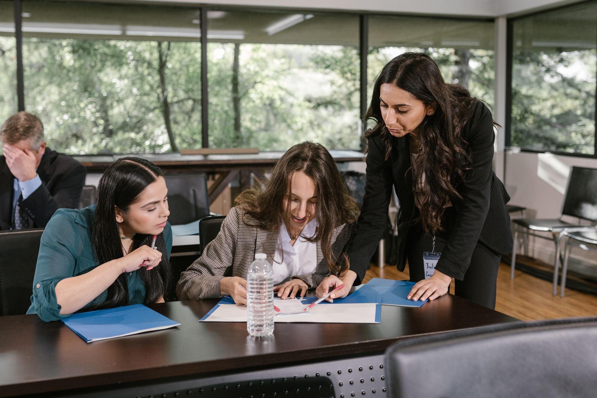 Three businesswomen engaged in a collaborative meeting in a contemporary office setting.