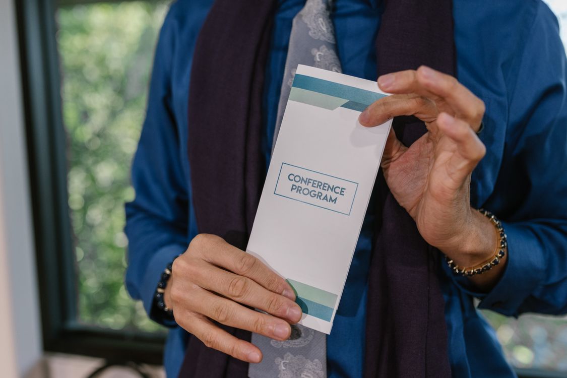 A Person Holding a Program Pamphlet · Free Stock Photo
