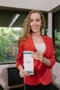 A Woman in a Red Blazer Holding a Conference Program Pamphlet