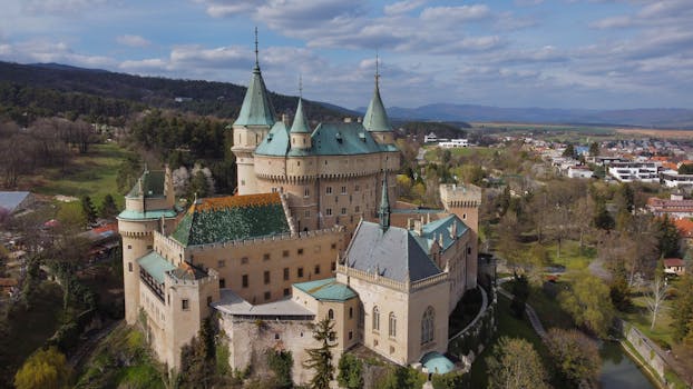 Stunning aerial view of Bojnice Castle in Slovakia, a historic medieval fortress surrounded by nature.