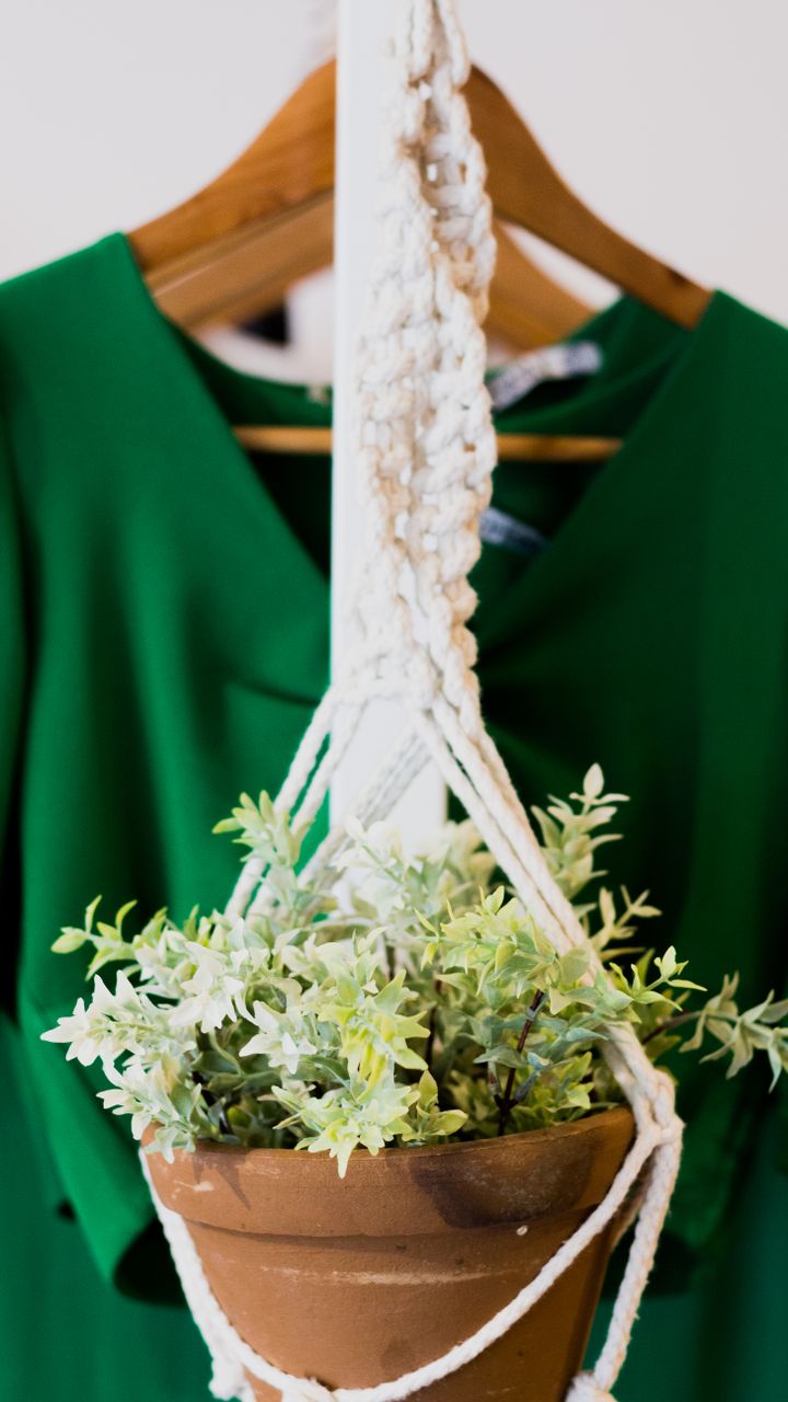 Woven jute plant hanger with a small trailing pothos plant hung behind a boho coffee bar