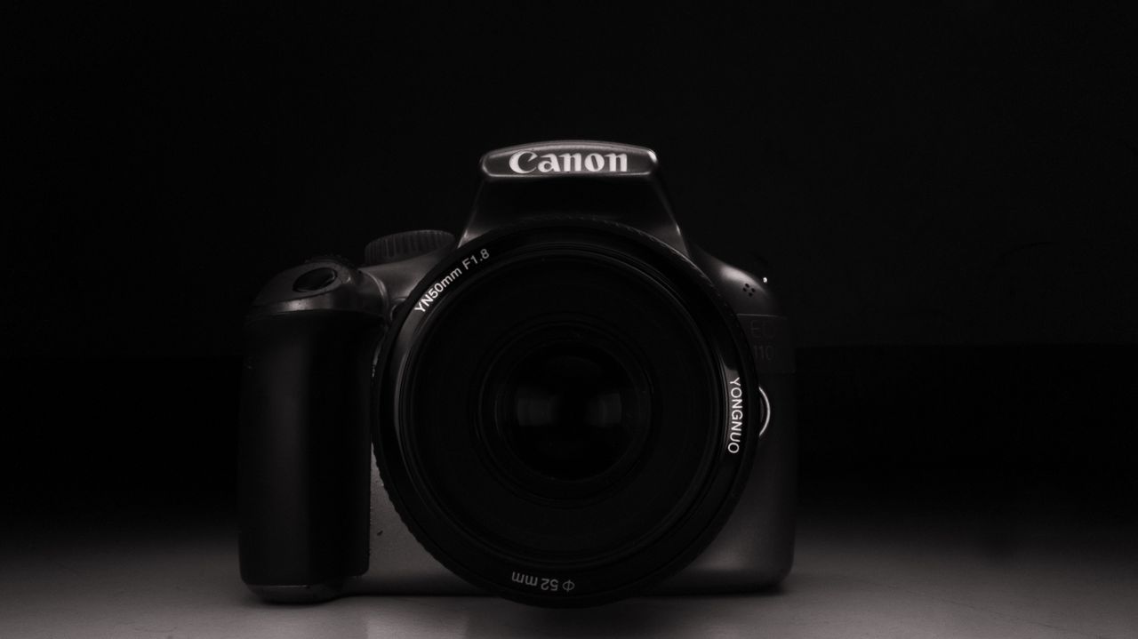 minimalist black and white portrait of a dslr camera with lens cap on