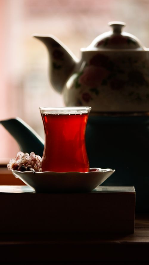 Free A warm and cozy setup featuring Turkish tea in a tulip glass with a traditional floral teapot. Stock Photo