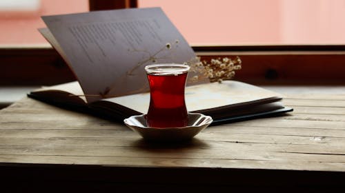 A Book and a Glass of Tea on a Wooden Table