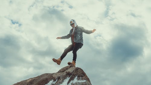 A Man Balancing while Standing on a Rock Formation