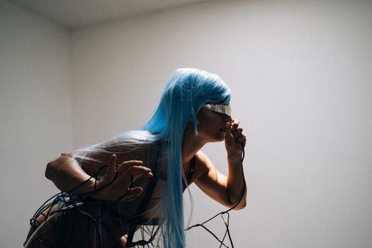 A futuristic woman with blue hair and cyberpunk elements in a dramatic pose.