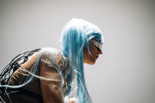 Portrait of a futuristic woman with blue hair and cyberpunk design, set in an artistic composition.