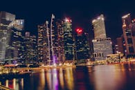 新加坡夜晚的水面上，映照着明亮的天际线，构成令人惊叹的城市景观