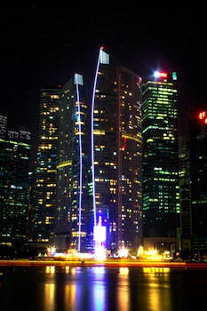 海滨的摩天大楼在夜间倒映出充满活力的城市景观