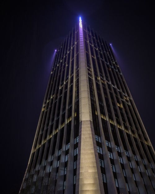 Free From below of high rise contemporary building with luminous roof in city against dark sky in night time Stock Photo